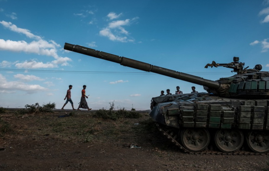 Foto dokumentasi pada 11 Desember 2020 memperlihatkan anak-anak muda berjalan di samping tank yang ditinggalkan milik pasukan Tigrayan di selatan kota Mehoni, Etiopia. 