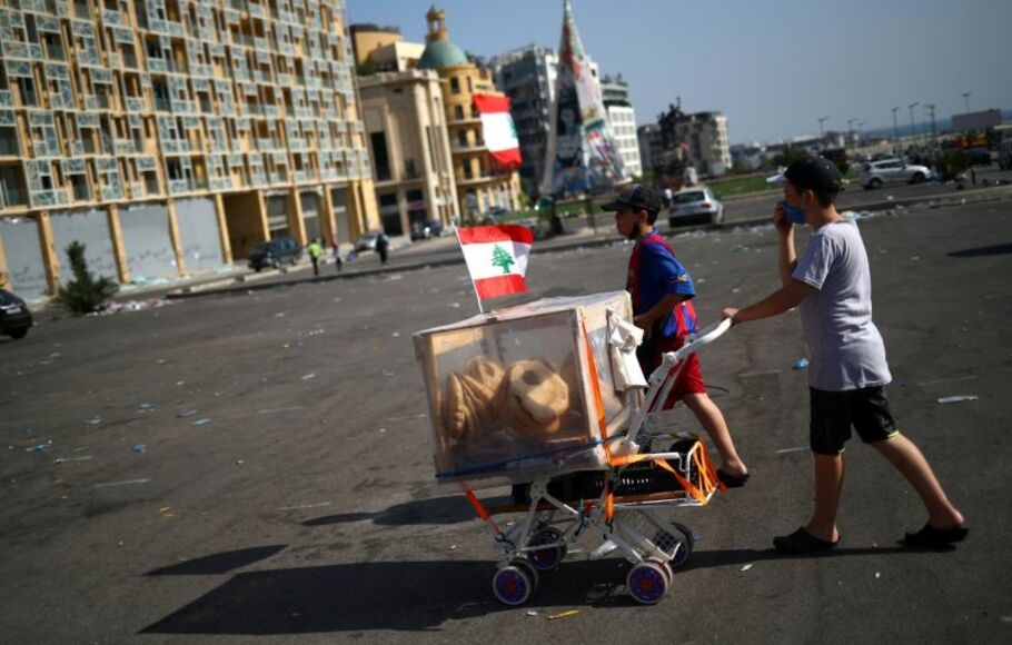 Dua anak lelaki menjual roti di sepanjang jalan di kawasan pelabuhan Beirut, Lebanon. 