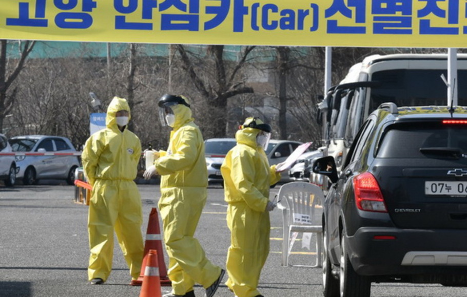 Anggota medis memandu pengemudi yang diduga memiliki gejala virus corona Covid-19, di fasilitas tes virus lintas kendara di Goyang, utara Seoul, pada 29 Februari 2020.