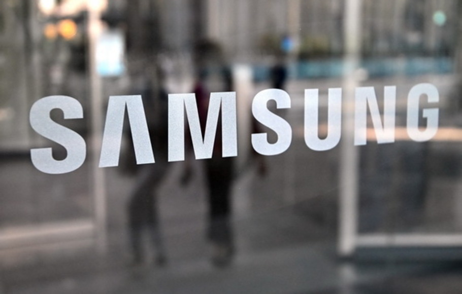 Orang-orang berjalan melewati logo Samsung yang dipajang di pintu kaca di gedung perusahaan Seocho di Seoul, Korea Selatan pada 27 Oktober 2021, setelah raksasa teknologi Korea Selatan Samsung Electronics membukukan lonjakan laba operasional sebesar 28 persen.