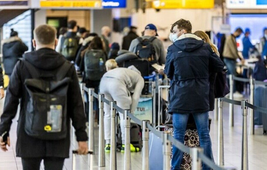 Para pelancong berdiri di aula keberangkatan Bandara Schiphol di Amsterdam, Belanda pada 17 Desember 2020. 