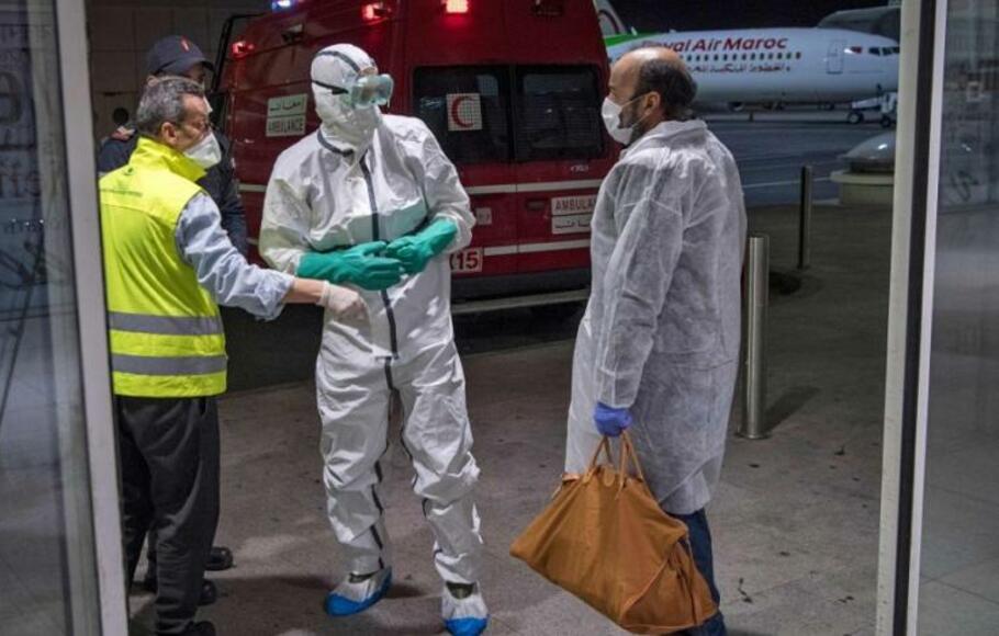 Petugas kesehatan Maroko memindai penumpang yang tiba dari Italia untuk virus corona Covid-19 di Bandara Internasional Casablanca Mohammed V pada 3 Maret 2020.