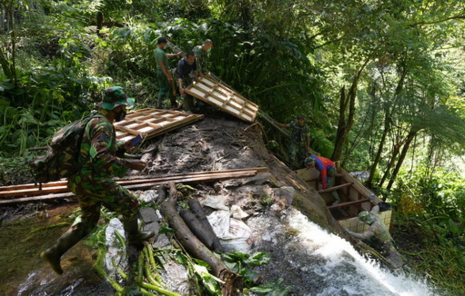 Anggota TNI memasang pompa untuk akses air bersih di lima desa di Bali hasil kerja sama Kodam IX Udayana dengan Shopee pada Juli 2021.