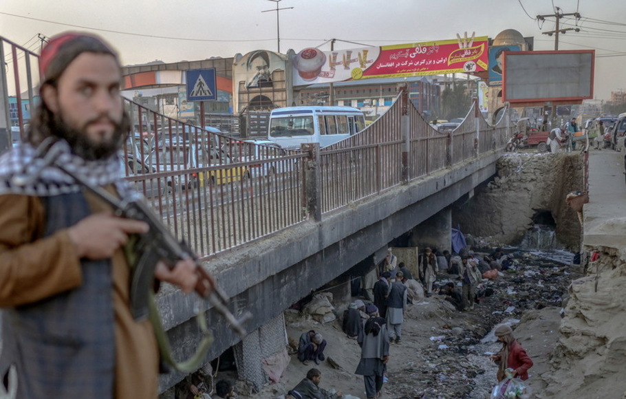 Seorang milisi Taliban berjaga di samping jembatan tempat ratusan orang kecanduan narkoba berkumpul di Kabul, Afghanistan, pada 9 Oktober 2021. 