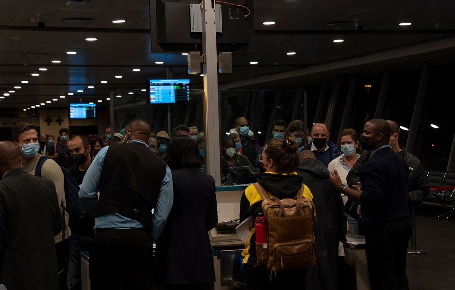 Penumpang mengantre untuk naik penerbangan ke Amsterdam di terminal keberangkatan internasional di Bandara Internasional OR Tambo di Johannesburg, Afrika Selatan pada 28 November 2021.