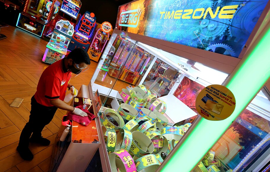 Petugas membersihkan mesin permainan pada peluncuran Timezone Rewards Reclaim Your Fun!, di Jakarta, Selasa, 30 November 2021.