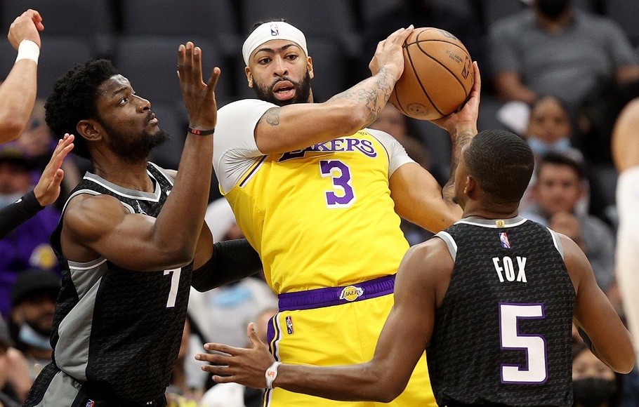 Pemain LA Lakers Anthony Davis dijaga dua pemain Sacramento Kings, Chimezie Metu dan De'Aaron Fox pada pertandingan basket NBA di Golden 1 Center, Sacramento, California.