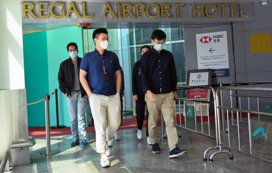 Orang-orang meninggalkan Regal Airport Hotel di bandara Chek Lap Kok di Hong Kong pada Jumat 26 November 2021, tempat varian Covid-19 baru yang dianggap sebagai ancaman besar terdeteksi pada seorang pelancong dari Afrika Selatan.