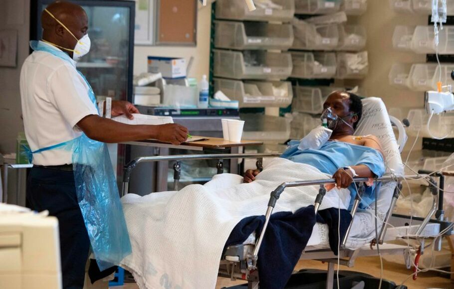 Perawat memberikan pelayanan pada pasien Covid-19 di satu rumah sakit dekat Cape Town, Afrika Selatan.