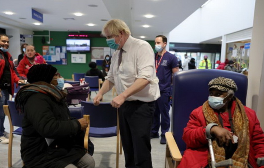 Perdana Menteri Inggris Boris Johnson bertemu warga yang mendapat vaksin penguat di tempat vaksinasi Covid-19, Lordship Lane Primary Care Center,  London, Inggris, Selasa 30 November 2021.