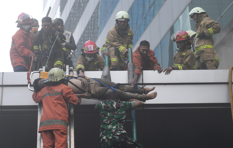 Petugas mengevakuasi korban kebakaran yang terjadi di Gedung Cyber 1, Jakarta, Kamis, 2 Desember 2021.
