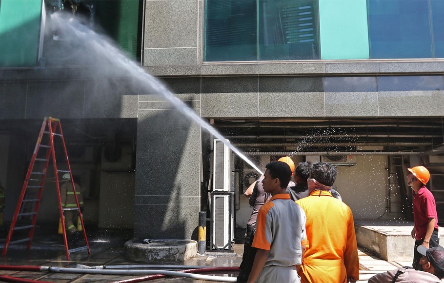 Petugas pemadam kebakaran memadamkan titik api, saat terjadi kebakaran di lantai 2 Gedung Cyber, Kuningan, Jakarta Selatan, Kamis, 2 Desember 2021.