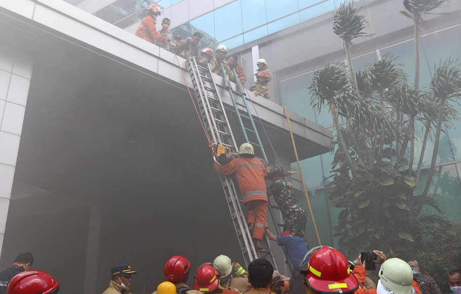 Sejumlah petugas pemadam kebakaran mengevakuasi korban yang terjebak, saat terjadi kebakaran di lantai 2 Gedung Cyber, Kuningan, Jakarta Selatan, Kamis, 2 Desember 2021.
