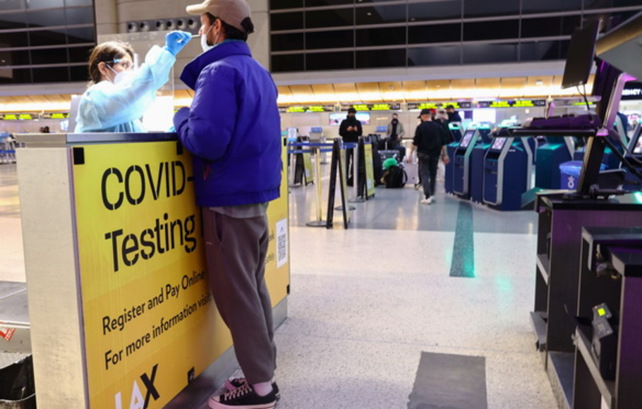 Seseorang diuji untuk Covid-19 di dalam Terminal Internasional Tom Bradley di Bandara Internasional Los Angeles (LAX)  di Los Angeles, California, AS pada Rabu 1 Desember 2021.AS  mewajibkan tes negatif untuk Covid-19 satu hari sebelum perjalanan, sebagai respons terhadap varian Omicron.