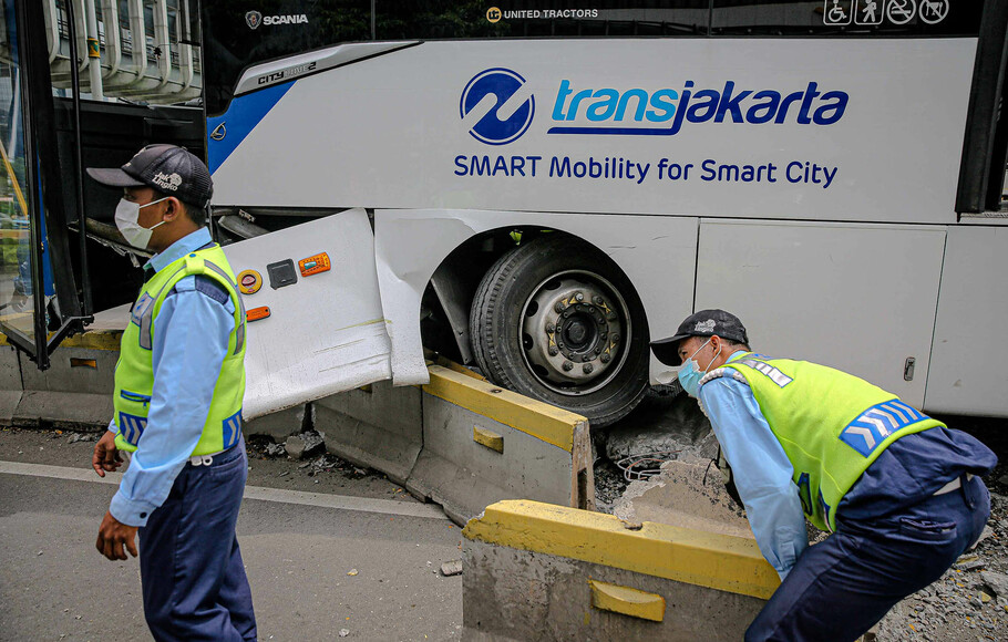 Petugas membongkar separator untuk evakuasi usai terjadinya kecelakaan bus Transjakarta yang menabrak separator di Jalan Jendral Sudirman, Jakarta Selatan, Jumat 3 Desember 2021.
