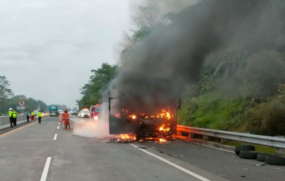 Petugas memadamkan api yang membakar sebuah bus di Km 433 Tol Semarang-Solo, Sabtu 4 Desember 2021 pagi. 