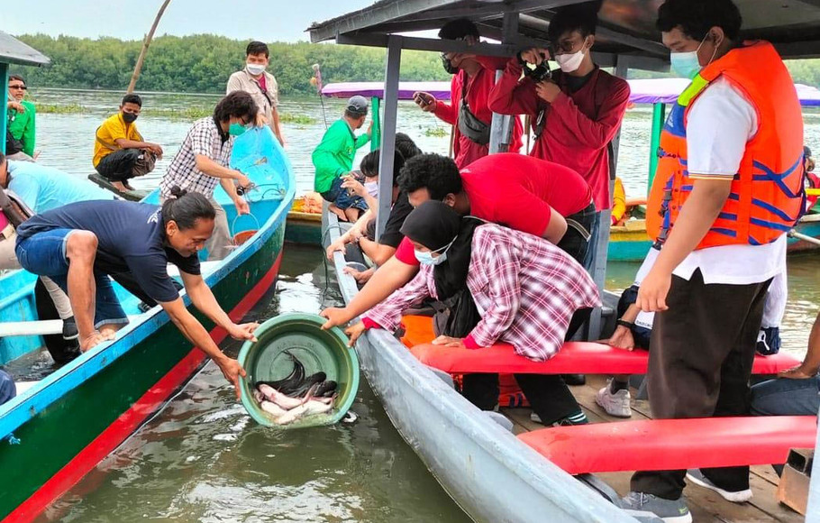 
Young Budhhist Association bersama Ecoton melepas ribuan jenis ikan di Wisata Kebun Raya Mangrove Gunung Anyar, Surabaya, Jawa Timur, Sabtu, 4 Desember 2021.