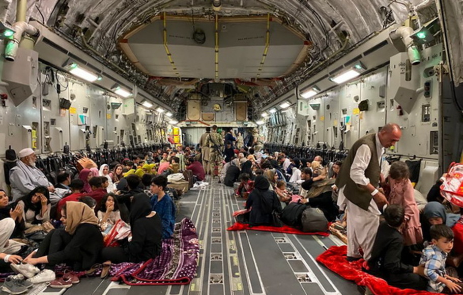 Orang-orang Afghanistan duduk di dalam pesawat militer AS untuk meninggalkan Afghanistan, di bandara militer di Kabul pada 19 Agustus 2021 setelah militer Taliban mengambil alih Afghanistan. 