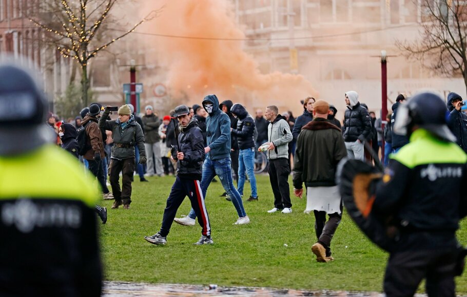 Polisi anti huru hara bentrok dengan pengunjuk rasa saat demonstrasi di alun-alun kota Museumplein, Amsterdam, Belanda pada 17 Januari 2021.
