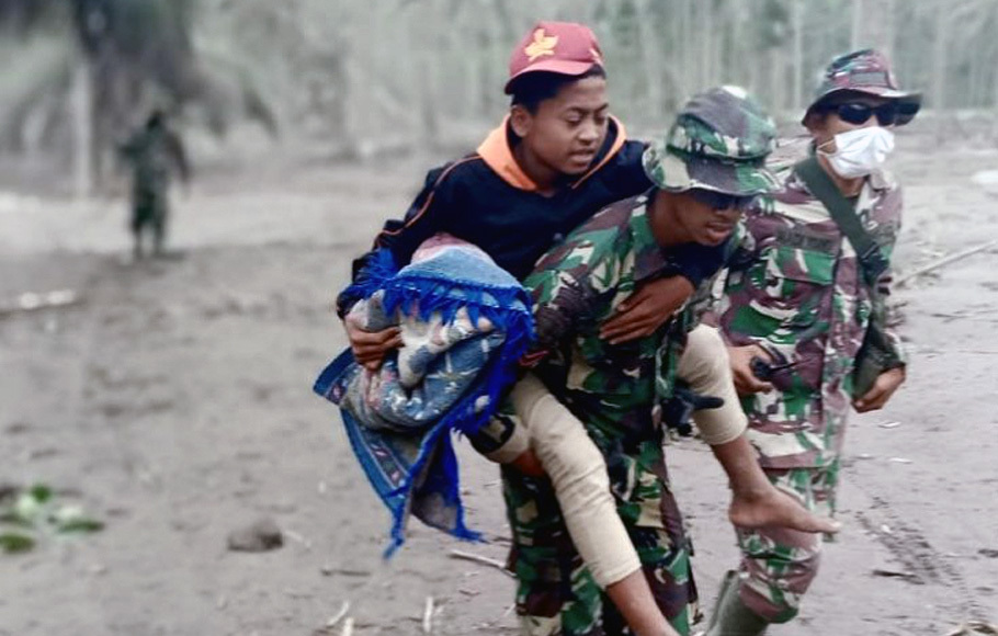 Prajurit TNI AU membopong seorang warga yang menjadi korban letusan Gunung Semeru di Lumajang, Jawa Timur, Senin, 6 Desember 2021. 
