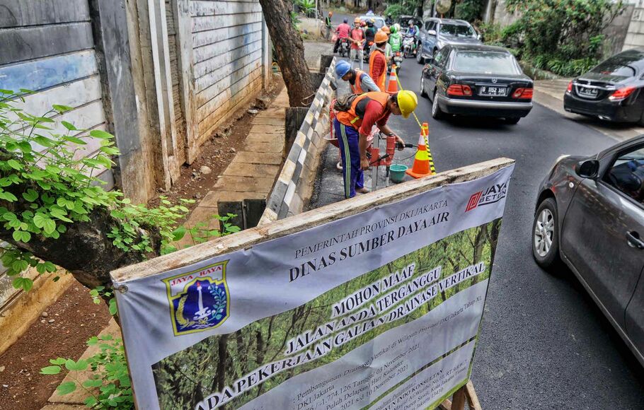 Pekerja mengebor aspal yang menutup sumur resapan di Jalan Lebak Bulus III, Cilandak, Jakarta Selatan, Senin, 6 Desember 2021.