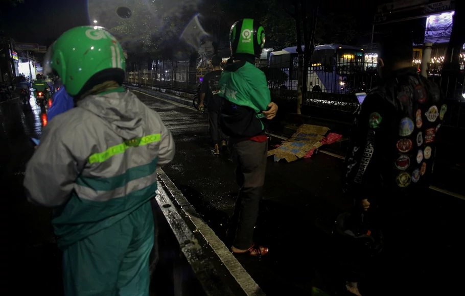 Sejumlah warga dan pengguna jalan menunggu mobil ambulance untuk evakuasi korban yang menjadi korban kecelakaan tertabrak bus Transjakarta di kawasan Jalan Margasatwa, Pasar Minggu, Jakarta Selatan, Senin 6 Desember 2021 malam.