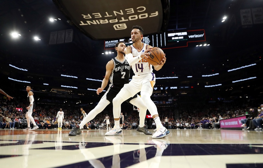 Pemain  San Antonio Spurs Bryn Forbes menjaga ketat pemain Phoenix Suns Landry Shamet pada pertandingan basket NBA di Phoenix, Arizona.