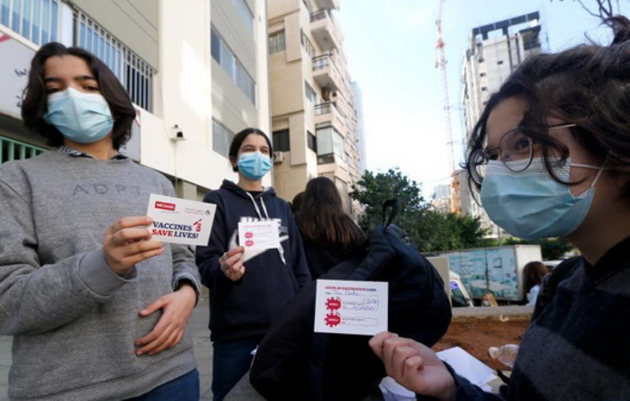 Para siswa menunjukkan kartu vaksinasi Covid-19 mereka di Beirut, Lebanon, pada Senin 6 Desember 2021. 