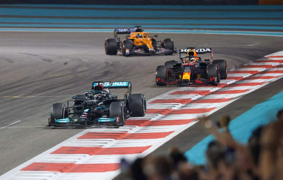 Pembalap Mercedes Lewis Hamilton 2021 (depan) berada di depan Max Verstappen dari tim Red Bull dalam balapan F1 GP Abu Dhabi di Sirkuit Yas Marina, Desember 12, 2021.