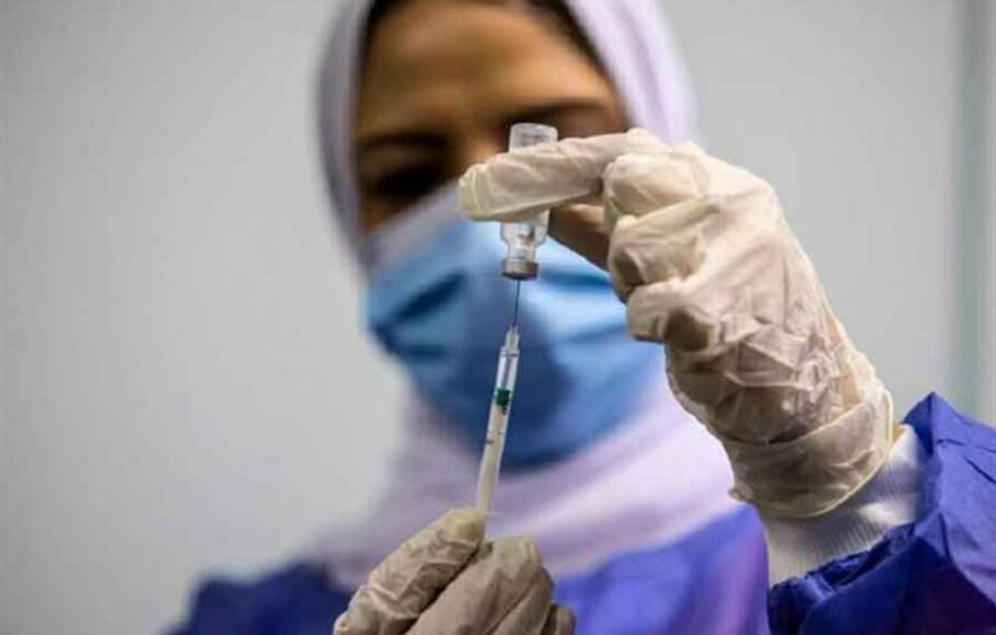 Seorang pekerja medis Mesir memberikan dosis vaksin Covid-19 Pfizer.