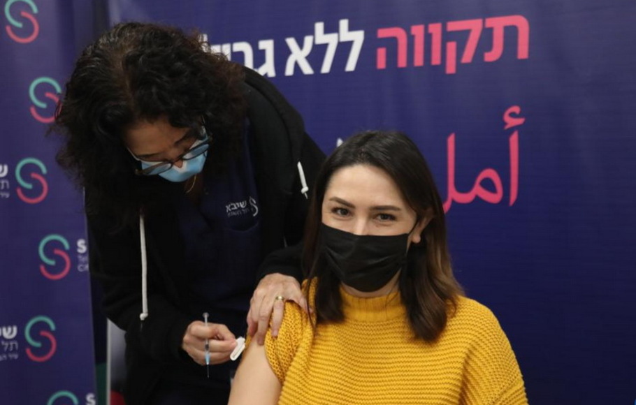 Seorang wanita Israel menerima dosis keempat vaksin Covid-19 di Pusat Medis Sheba di kota Ramat Gan, Israel tengah, pada Selasa 28 Desember 2021. Israel memulai uji coba vaksin virus corona dosis keempat pada Senin. 