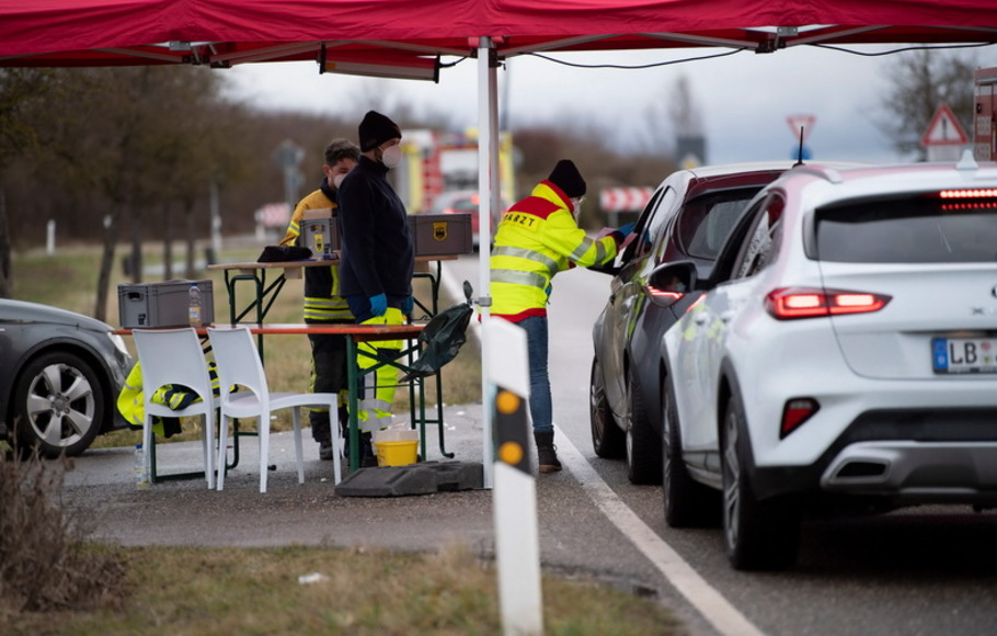 Mobil-mobil mengantre di stasiun vaksinasi drive-in, di jalan pedesaan dekat Loechgau, Jerman selatan, pada Kamis 30 Desember 2021, di tengah pandemi virus corona yang sedang berlangsung. 
