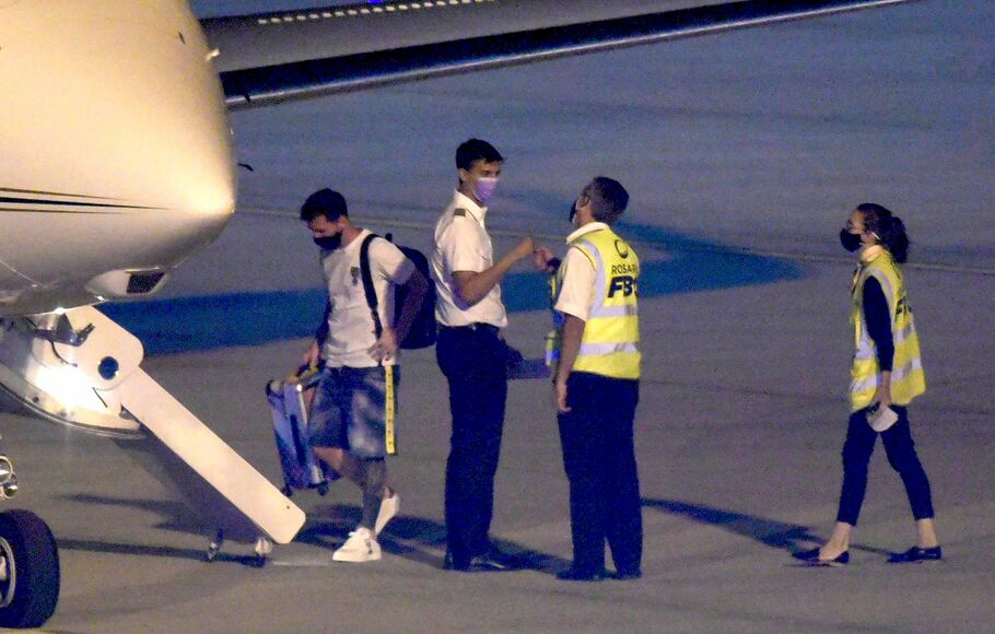 Striker Paris Saint-Germain (PSG) Lionel Messi (kiri) menaiki pesawat menuju Paris dari Bandara Islas Malvinas, di Rosario, Santa Fe, Argentina, Rabu,  5 January 2022 setelah terpapar Covid-19. 