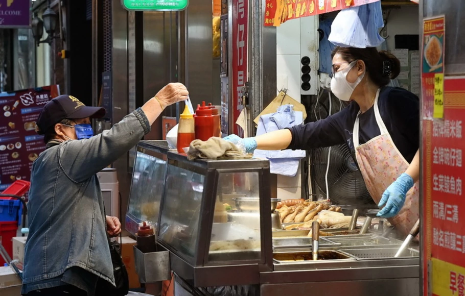 Seorang pelanggan (kiri) membeli makanan untuk dibawa pulang dari satu restoran di Hong Kong pada Rabu 5 Januari 2022, setelah kota tersebut mengumumkan kontrol anti-coronavirus baru yang ketat.