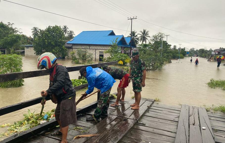 Personel TNI dari Koramil 1701-11/Jayapura saat membantu masyarakat yang terdampak banjir di Kampung Nimbokrang Distrik Nimbokrang Kabupaten Jayapura, Provinsi Papua, Minggu 9 Januari 2022.