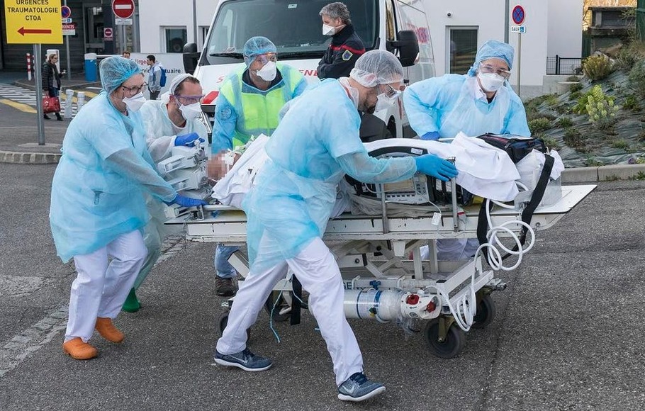 Staf medis mendorong seorang pasien di atas ranjang ke helikopter medis yang menunggu di satu rumah sakit, Prancis timur, pada 17 Maret 2020, di tengah merebaknya virus corona baru. 
