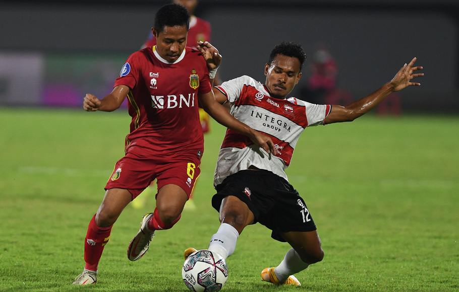 Gelandang Bhayangkara FC Evan Dimas Darmono (kiri) berebut bola dengan pemain Madura United Haris Tuharea dalam kompetisi Liga 1 di Stadion I Wayan Dipta, Gianyar Bali, Jumat, 14 Januari 2022. Bhayangkara FC mengalahkan Madura United, 3-2. 