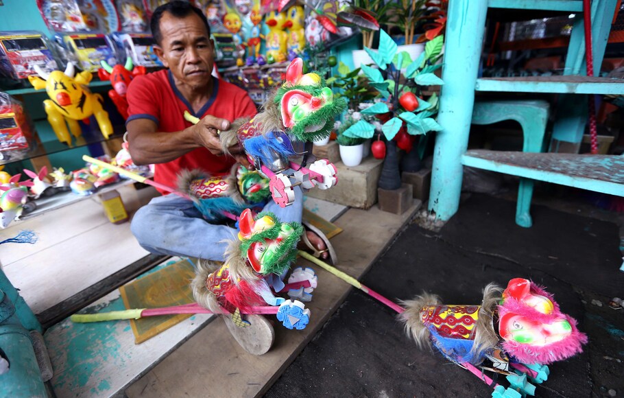 Pedagang mainan merapihkan mainan tradisional barongsai otok-otok yang dijualnya di Pamulang, Tangerang Selatan, Banten, Senin, 17 Januari 2022. Mainan tradisional anak yang terbuat dari bahan daur ulang seperti plastik, kaleng, dan gabus tersebut, dijual dengan harga rata-rata Rp20 ribu per buah. 
