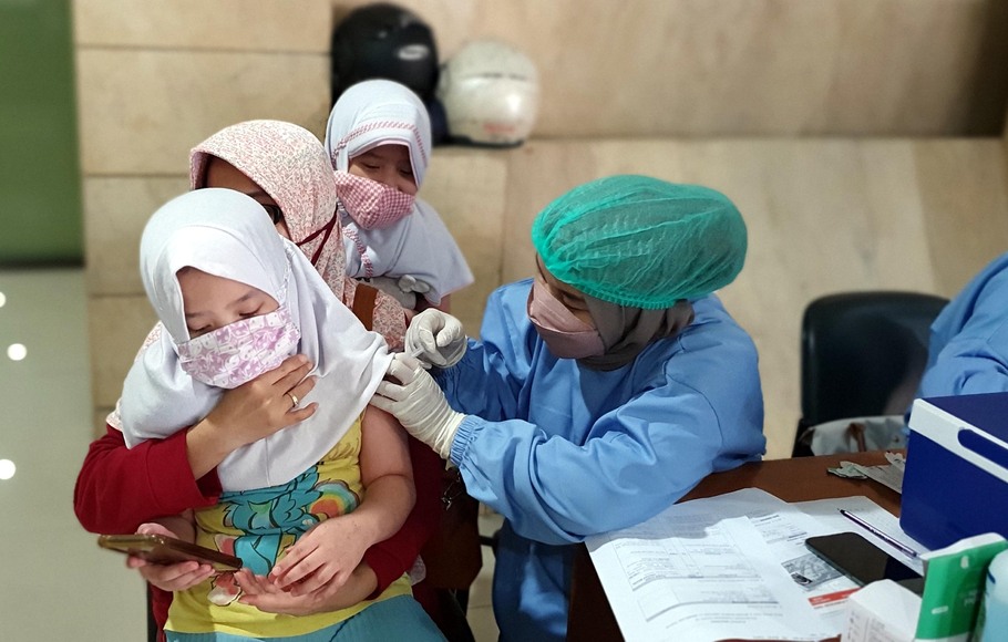 Tenaga kesehatan memberikan suntikan vaksin Covid-19 kepada anak-anak di Kawasan Jakarta Timur, Selasa, 18 Januari 2022. Sentra vaksinasi tersebut dimulai pada hari Senin 17 Januari hingga 22 Januari 2022 mendatang.