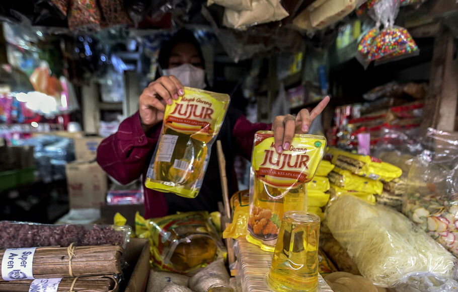 Pedagang pasar menunjukkan minyak goreng kemasan 1 leter di sebuah pasar tradisional di Jakarta, Rabu, 19 Januari 2022.