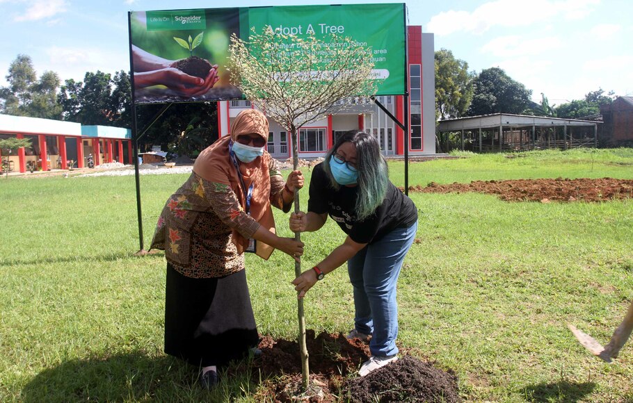 Head of CSR Schneider Electric for East Asia & Japan Ratri Wuryandari (kanan), secara simbolis menyerahkan sekitar 50 bibit pohon kepada Kepala SMK Negeri 15 Kota Bekasi Supriatin (Kiri) dalam program Adopt a Tree’, di Bekasi, Jawa Barat, Jumat, 21 Januari 2022. Kegiatan ini merupakan bagian dari program ‘Adopt a Tree’ yang ditargetkan menggandeng Sekolah Menengah Kejuruan (SMK) untuk mempromosikan lingkungan sekolah hijau.