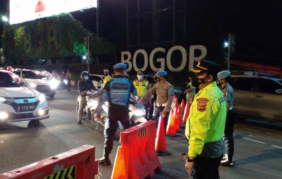 Sejumlah petugas polisi melakukan penyekatan saat pemberlakuan penutupan Jalan Pajajaran, Jumat 21 Januari 2021 malam.

