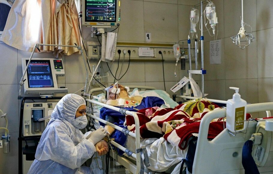 Seorang petugas medis merawat seorang pasien yang terinfeksi virus corona atau Covid-19 di satu rumah sakit di Teheran, Iran.