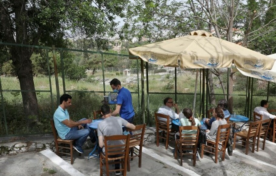 Warga mengunjungi kafe dan restoran di tempat terbuka di distrik Plaka, di Athena, Yunani, yang kembali beroperasi setelah enam bulan tutup akibat pandemi Covid-19.
