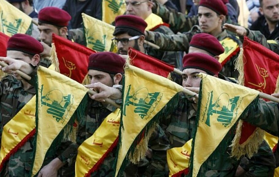 Anggota Hizbullah Syiah Lebanon memegang bendera saat pemakaman seorang pejuang Hizbullah, yang tewas saat berperang bersama pasukan pemerintah Suriah di Suriah, pada 1 Maret 2016. 