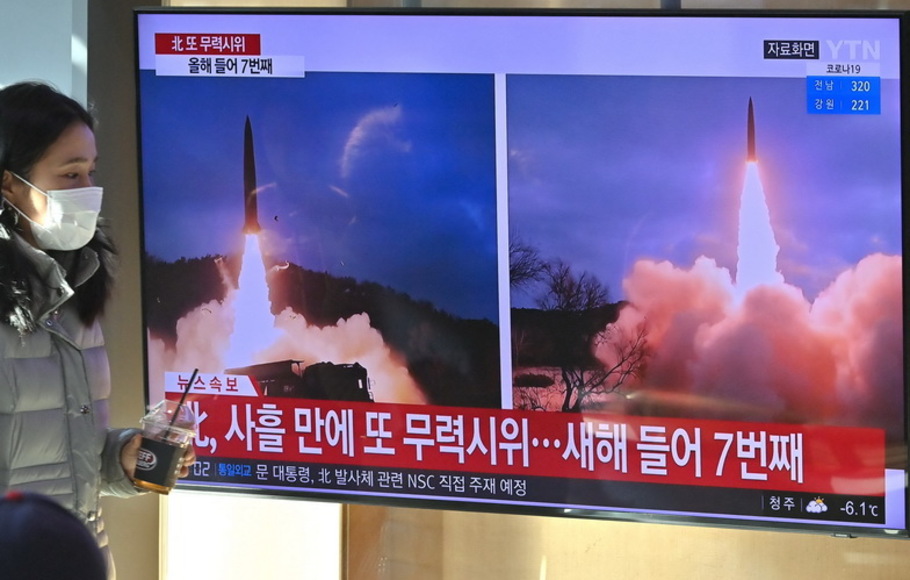 Seorang wanita berjalan melewati layar televisi yang menunjukkan siaran berita dengan rekaman file uji coba rudal Korea Utara, di sebuah stasiun kereta api di Seoul pada Minggu 30 Januari 2022, setelah Korea Utara menembakkan 