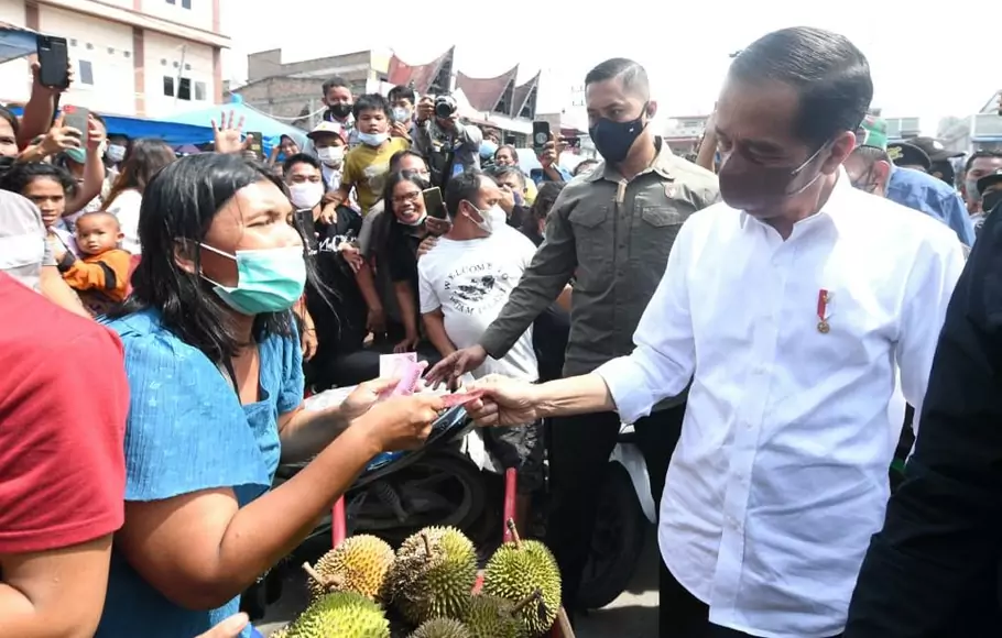 Presiden Joko Widodo (Jokowi) membagikan bantuan langsung tunai bagi para pedagang kaki lima dan warung di Pasar Porsea, Kabupaten Toba, Provinsi Sumatera Utara, Rabu 2 Februari 2022.
