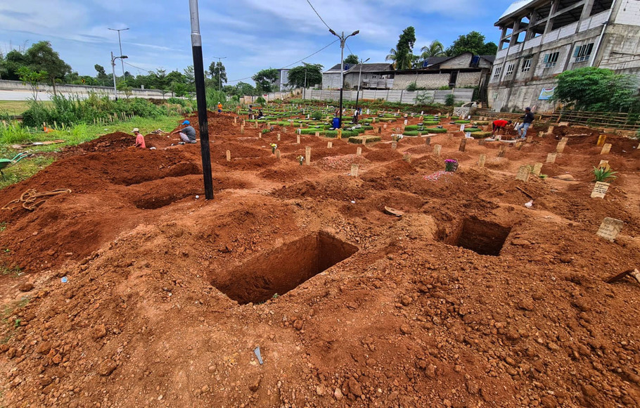 Pekerja membuat lubang makam untuk jenazah kasus Covid-19 di TPU khusus Covid-19 di Jombang, Tangerang Selatan, Banten, Rabu, 23 Februari 2022. Satuan Tugas (Satgas) Penanganan Covid-19 mengumumkan adanya penambahan 257 pasien Covid-19 yang meninggal dunia pada Selasa kemarin. 