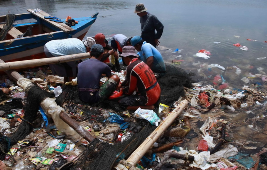 Nelayan memilah hasil tangkapan dari jaring saat mereka menangkap ikan di perairan tercemar yang dipenuhi sampah plastik di Bandar Lampung, pada Senin 21 Februari 2022. 