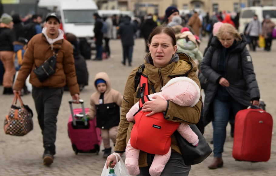Para pengungsi dari Ukraina timur terlihat di luar stasiun kereta api di kota Lviv, Ukraina barat pada Rabu 2 Maret 2022.  Rusia meningkatkan serangan pengeboman dan serangan rudal di kota-kota Ukraina pada 2 Maret 2022. 